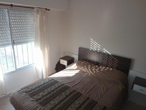 a bedroom with a bed and a window at Departamento en Morón in Morón