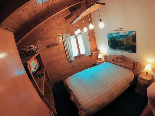 1 dormitorio con 1 cama en una cabaña de madera en Los Cerezos en San Martín de los Andes