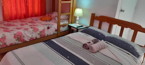 1 dormitorio con 2 camas individuales y mesa con lámpara en Hotel Quilla Wasi, en Lunahuaná