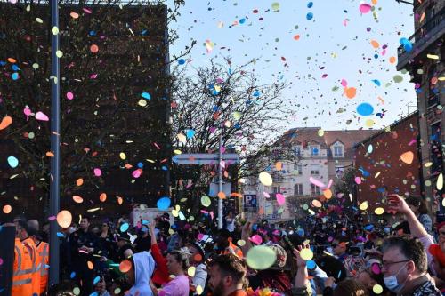 Eine Menge Leute auf einer Straße mit Konfetti in der Unterkunft Cœur de ville avec parking+gare à proximité de Disney et Paris in Lagny