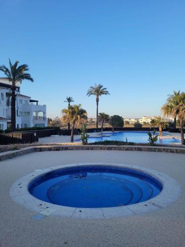 ein großer runder Pool mit Palmen im Hintergrund in der Unterkunft 2 chambres à coucher à Sucina in Murcia