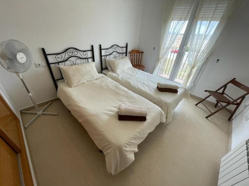 1 Schlafzimmer mit 2 Betten mit weißer Bettwäsche und einem Ventilator in der Unterkunft 2 chambres à coucher à Sucina in Murcia