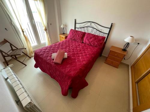 ein Schlafzimmer mit einem roten Bett mit einer roten Bettdecke in der Unterkunft 2 chambres à coucher à Sucina in Murcia