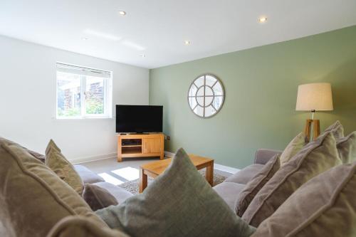 a living room with a couch and a tv at Trewhiddle 41 by Together Travel - Stylish Coastal Countryside Retreat in St Austell