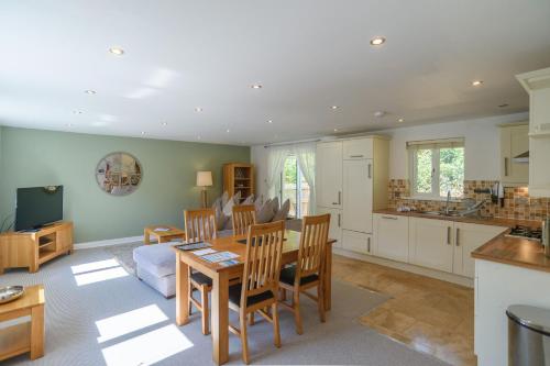 a kitchen and living room with a table and chairs at Trewhiddle 41 by Together Travel - Stylish Coastal Countryside Retreat in St Austell