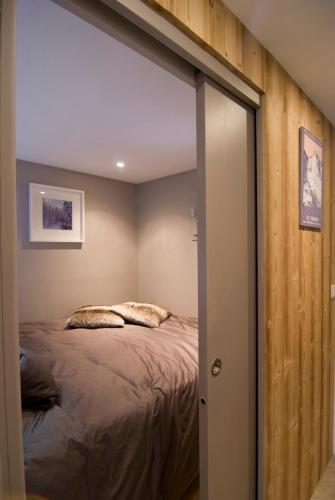 une chambre avec un lit et un miroir dans l'établissement Ski aux pieds Les 3 Vallées, aux Menuires