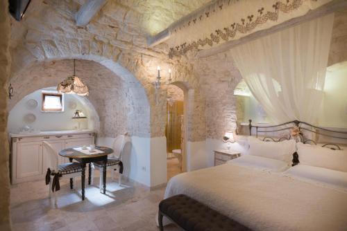 - une chambre avec un grand lit et un mur en pierre dans l'établissement Romantic Trulli, à Alberobello