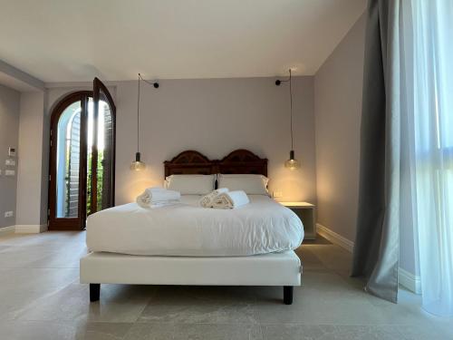 a bedroom with a white bed with two towels on it at Agriturismo La Rondinella in Lazise