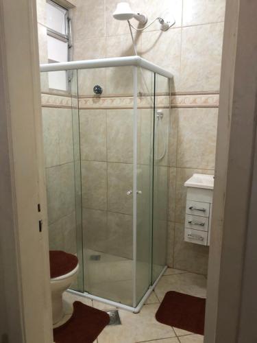 uma casa de banho com uma cabina de duche em vidro e um WC. em Carioca no Rio de Janeiro