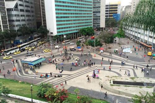 um grupo de pessoas andando em torno de uma praça em uma cidade em Carioca no Rio de Janeiro