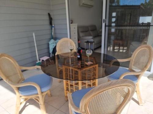 a dining room table with chairs and a glass table at Glass House Mountains Retreat in Beerwah
