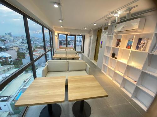 a room with tables and couches in a building at GOODTECH LUXURY Hotel & Apartment in Danang