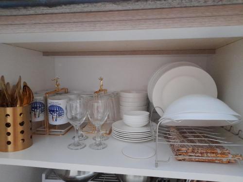 a shelf with plates and wine glasses and dishes at FourSphere staycation in Manila