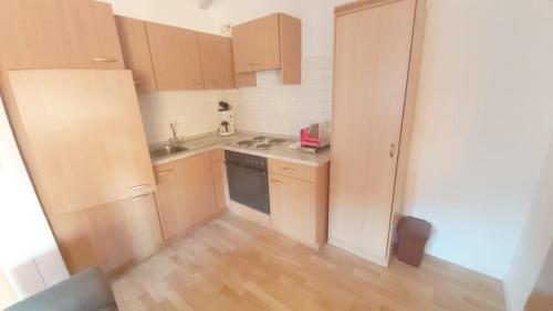 a small kitchen with wooden cabinets and a kitchen at Edenhofer-Kollmer in Drachselsried