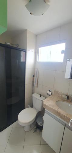 Baño blanco con aseo y lavamanos en Apple Flat 501, en Natal