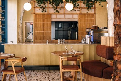 a restaurant with tables and chairs and a kitchen at Independente Bica in Lisbon