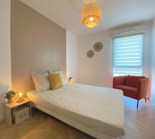 une chambre avec un lit blanc et une chaise rouge dans l'établissement Appartement vue mer en Roof-Top, à Marseille
