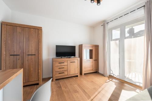 a living room with a tv and a large window at HoHome Comfy Apartments in Warsaw