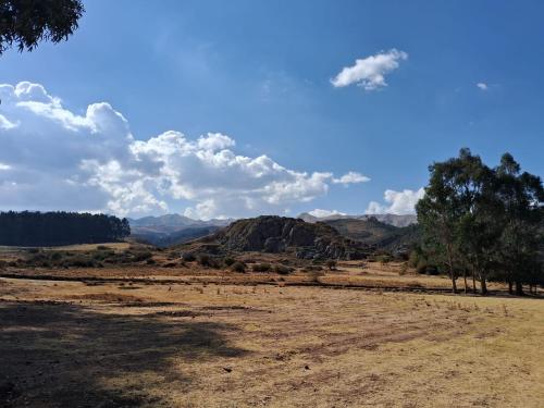 a desert field with trees and mountains in the background at KOSKO Casa Hotel in Cusco