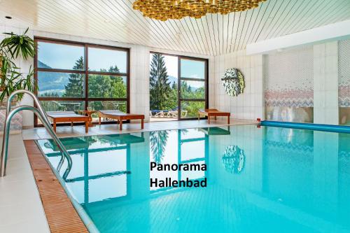uma piscina num quarto de hotel com uma grande janela em Appartement Predigstuhlblick mit Indoorpool und Sauna em Bad Goisern
