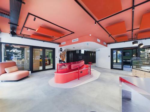 a room with red furniture in a building at Hife Gentilly Paris Sud Porte d'Italie in Gentilly