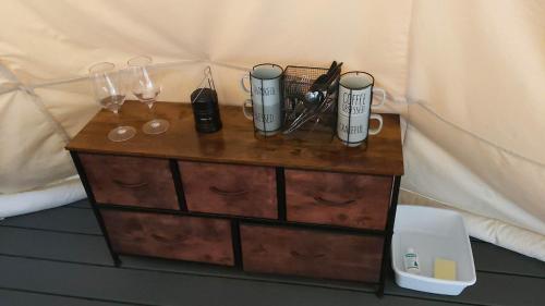 a wooden dresser with glasses and wine glasses on it at Ravens Myth - Luxury Glamping - Sleeps 2 