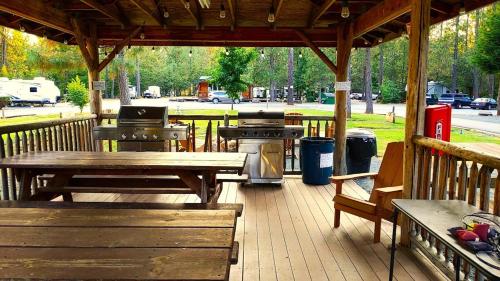 a patio with tables and benches and a grill at Ravens Myth - Luxury Glamping - Sleeps 2 