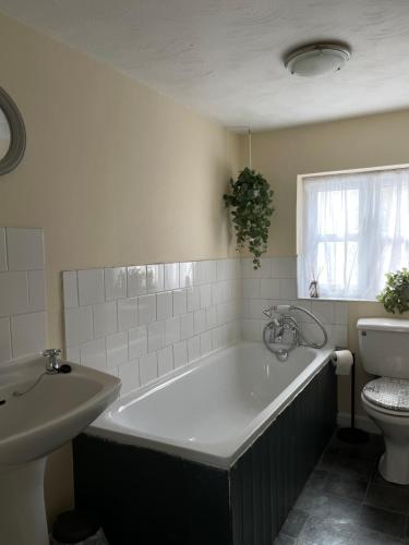 a bathroom with a large tub and a toilet at Charming cottage in Lyng