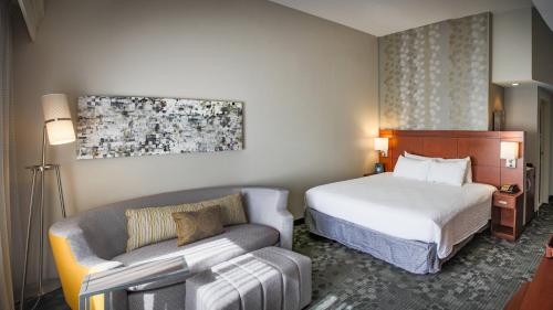 a hotel room with a bed and a couch at Courtyard by Marriott Norman in Norman