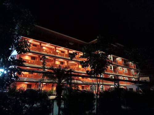 a lit up building with trees in front of it at Nangnon Hill Hug Hotel in Ban Pa Muat