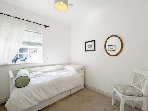 Un dormitorio blanco con una cama y una ventana. en Emsdale House, en Emsworth