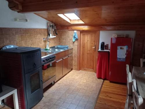 een keuken met een fornuis en een rode koelkast bij A&J House in Canale San Bovo