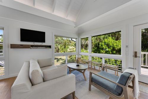 a living room with a couch and a tv at Ka Hale Olu at Anini Beach TVNC#4218 in Kilauea