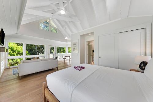 a white bedroom with a large bed and a couch at Ka Hale Olu at Anini Beach TVNC#4218 in Kilauea