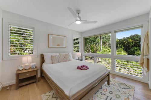 a bedroom with a bed and two windows at Ka Hale Olu at Anini Beach TVNC#4218 in Kilauea