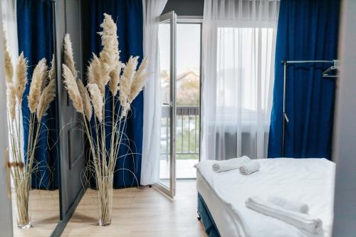 a bedroom with a bed and blue curtains and a window at Modern Lux Apartment 2 in Brčko