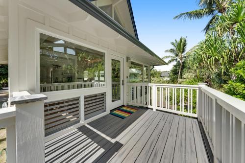 a house with a wooden deck with a balcony at Ka Hale Olu at Anini Beach TVNC#4218 in Kilauea