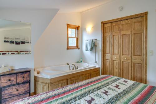ein Bad mit einem Bett, einer Badewanne und einem Waschbecken in der Unterkunft Backus Lakefront Cabin with Fire Pit, Dock Access! 