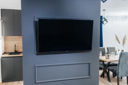 a flat screen tv on a blue wall in a living room at Modern Lux Apartment 2 in Brčko