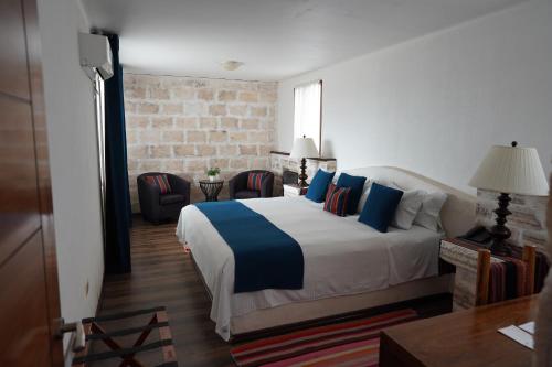 a bedroom with a large bed with blue pillows at Hotel de Sal Luna Salada in Colchani