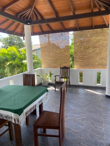 a patio with a table and chairs and a wooden ceiling at Mirissa Gold Rush Villa in Mirissa