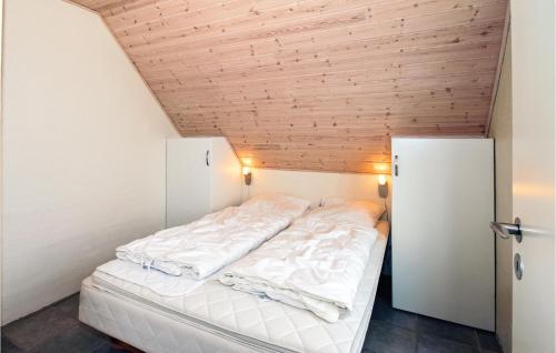 KlegodにあるStunning Home In Ringkbing With 4 Bedrooms, Sauna And Wifiの木製の天井の客室のベッド1台分です。