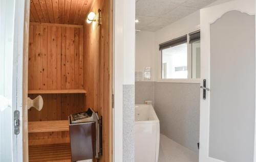 a bathroom with a white toilet and a window at Awesome Home In Ringkbing With 3 Bedrooms, Sauna And Wifi in Søndervig