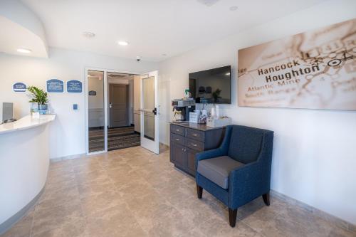 a waiting room with a blue chair and a counter at Independence Stay Hotel and Long term suites in Houghton