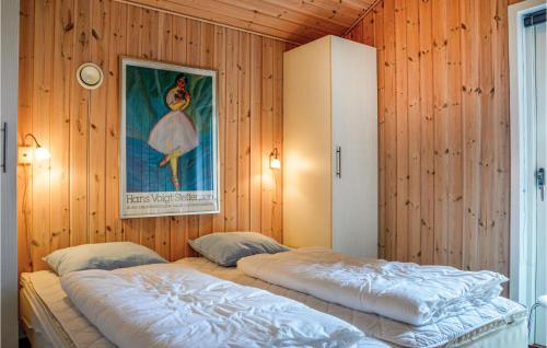 Fjand GårdeにあるGorgeous Home In Ulfborg With Kitchenの木製の壁にベッド2台が備わるベッドルーム1室