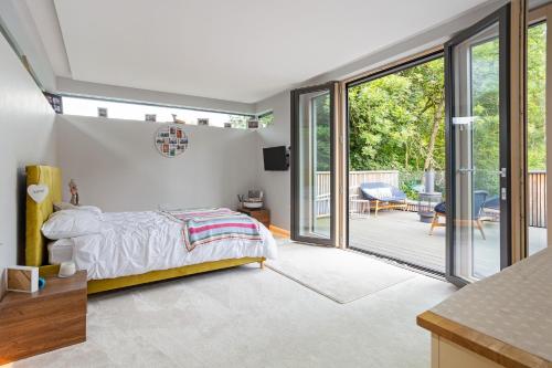 a bedroom with a bed and sliding glass doors at Millside in Stroud