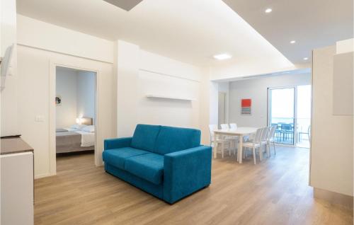 una sala de estar con una silla azul y un dormitorio en Pet Friendly Apartment In Pineto With Outdoor Swimming Pool, en Pineto