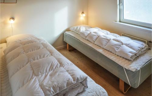 Sønder NissumにあるAwesome Home In Ulfborg With 3 Bedrooms And Wifiの窓付きの客室で、ベッド2台が備わります。