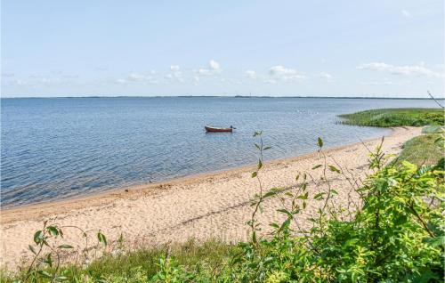 a boat in the water on a beach at Holiday Home Lathyrusvej Ulfborg Ii in Sønder Nissum