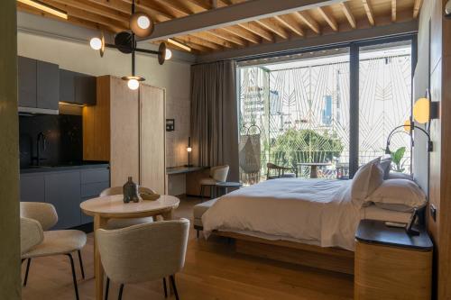 a bedroom with a bed and a table and a kitchen at Colima 71 - Casa de Arte Hotel in Mexico City